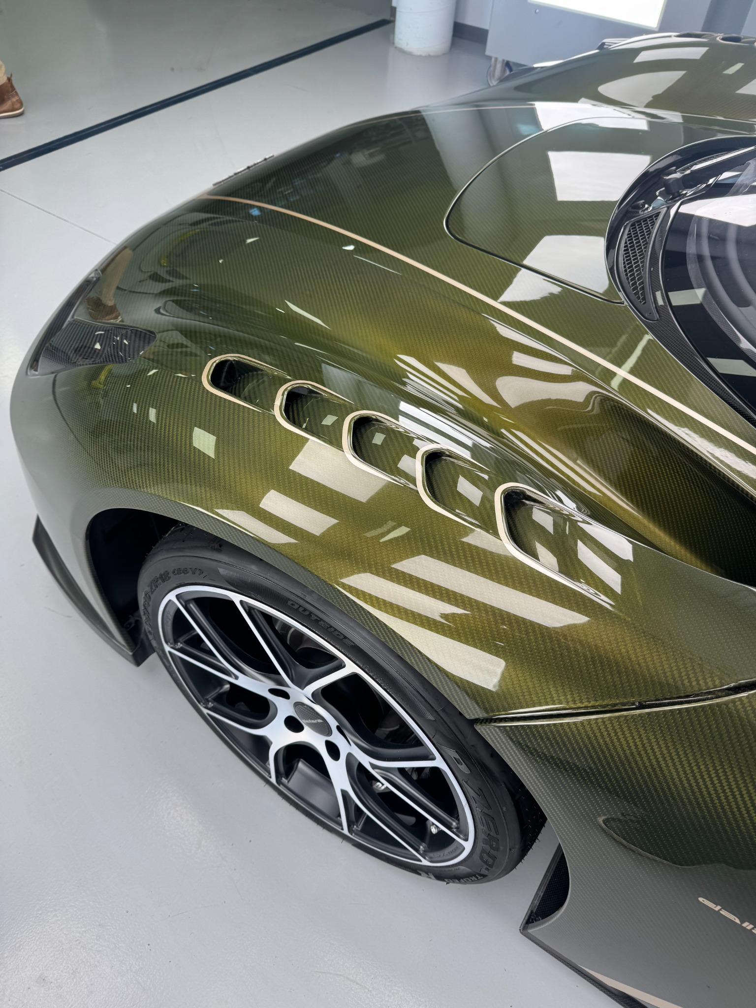 Close-up of exposed carbon fiber bodywork and wheel detail on a Dallara Stradale