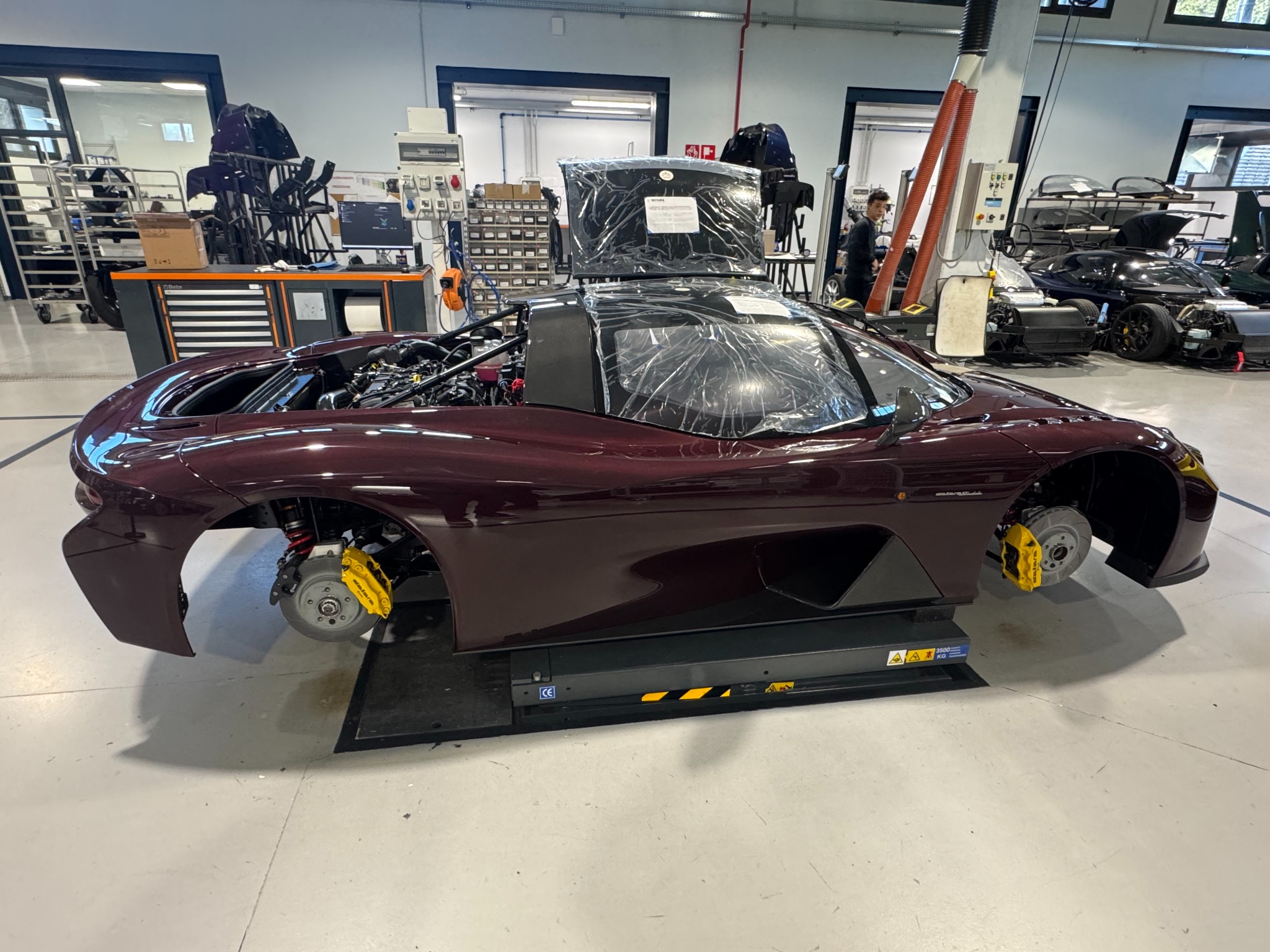 Partially assembled Dallara Stradale in a factory workshop with wheels removed