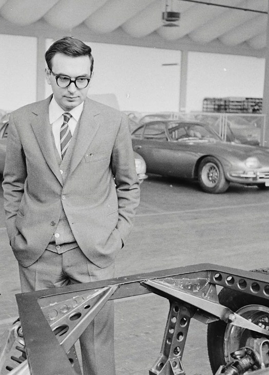 Historical photograph of Giampaolo Dallara beside an early automotive chassis
