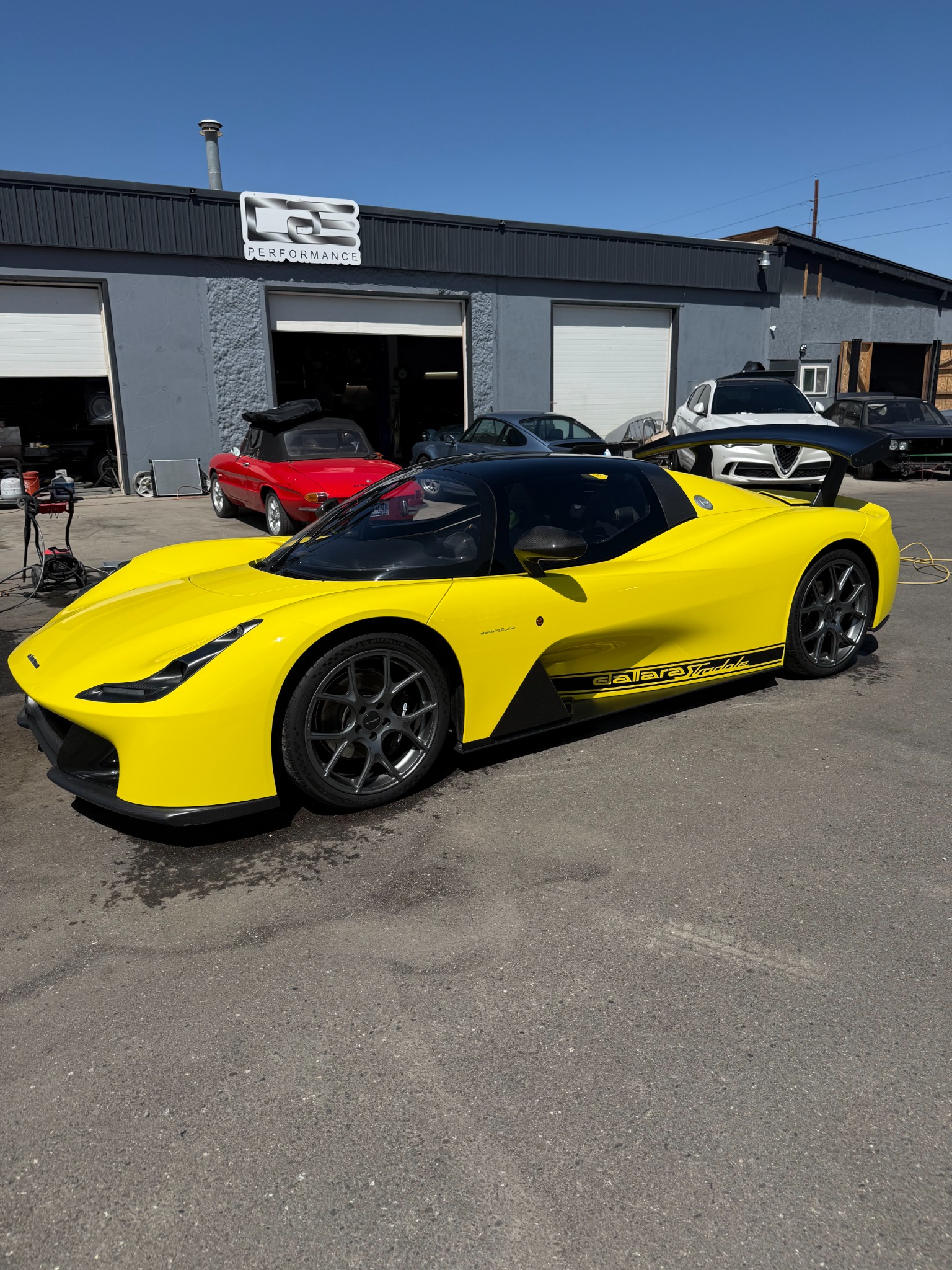 Yellow Dallara Stradale Chassis #007 outside the Grand Junction workshop