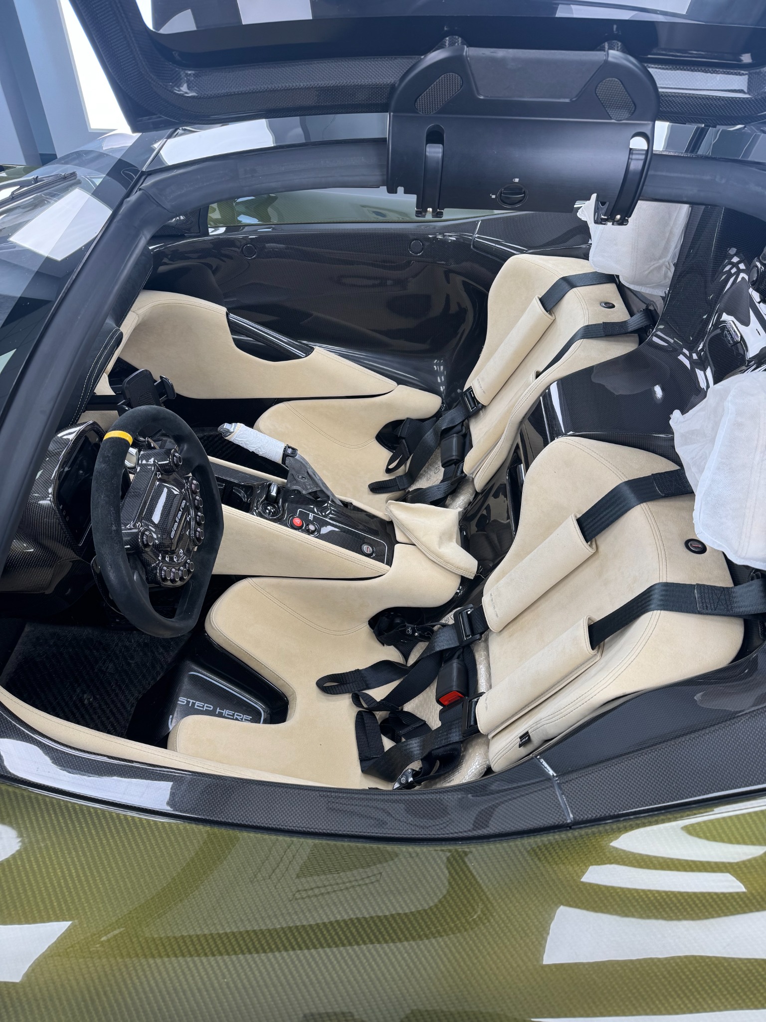 Dallara Stradale cockpit with carbon-fiber tub, racing seats, harnesses, and steering wheel